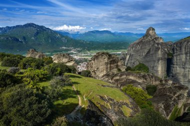 Meteora kayalıklarından vadideki Kalambaka 'ya, dağlara, karla kaplı tepelere, Yunanistan' ın merkezindeki manzaraya, bulutlu mavi gökyüzüne, kopyalama alanına, seçilmiş odak noktasına.