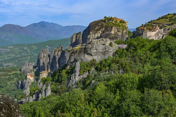 様々な岩の崖の上に位置する4つの修道院 ギリシャの有名な観光地 谷と背景の高い山 青い曇りの空 コピースペースのあるメテオラの風景 — ストック写真