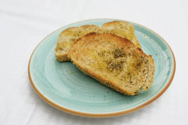 Toastbrot Mit Olivenöl Kräutern Und Knoblauchsalz Auf Blauem Teller Kopierraum — Stockfoto