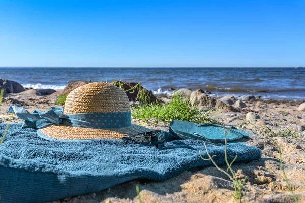 天然のビーチで青いタオルに帽子とフリップフロップを投げ 観光リゾート近くの夏休みBoltenhagen バルト海 ドイツ コピースペース 上からの眺め 選択した焦点 — ストック写真