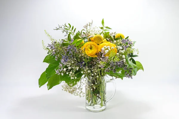 Bukiet Wiosennych Kwiatów Kolorze Żółtym Niebieskim Zielonym Szklanym Dzbanku Jasnoszarym — Zdjęcie stockowe