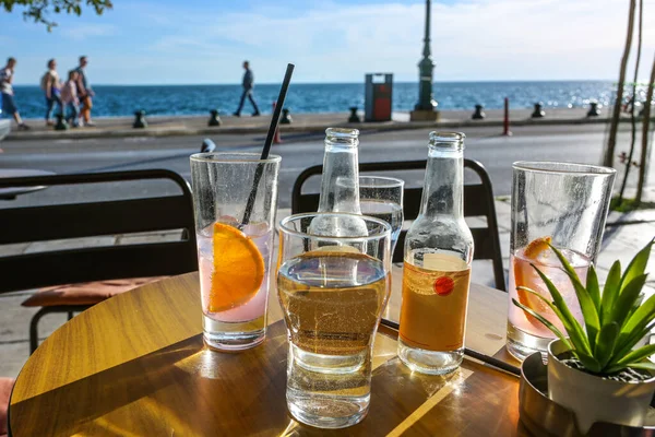 Refreshing Drinks Drinking Glasses Bottles Table Seaside Street Cafe Blurry — Stock Photo, Image