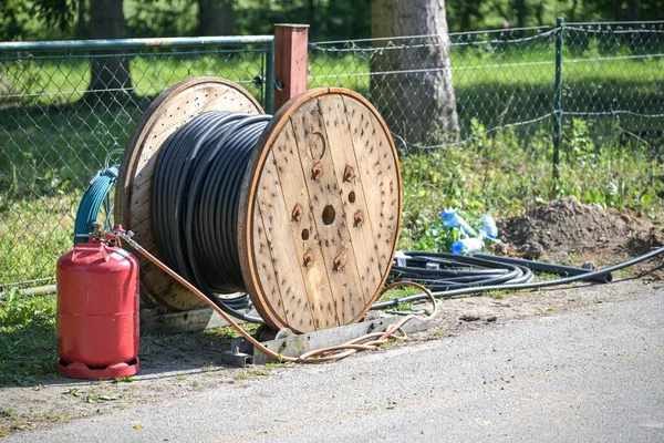 农村道路房屋连接用带有盘绕的黑色电力电缆的大型木制卷轴 能源和电力概念 选定重点 — 图库照片