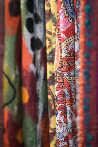 机织毛织物 色彩斑斓 多数为红色 挂在商店里销售 复制空间 选择焦点 非常狭窄的领域深度 — 图库照片