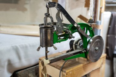 Bir zanaatkârın atölyesine çarkıfelek ve dönen ayakla deri işi için endüstriyel dikiş makinesi, çantalar, kıyafetler, ayakkabılar, mobilya döşemeleri ya da araba içi, seçilmiş odak noktası