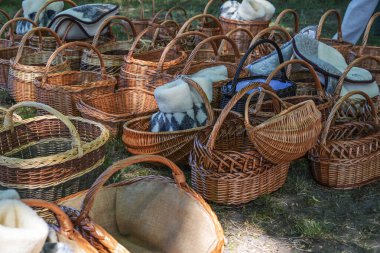 Almanya 'da tarihi bir zanaat pazarında satılık hasır sepetler ve koyun derisi terlikler, seçilmiş odak, dar alan derinliği