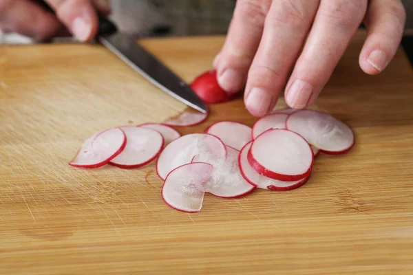Hands Cut Radishes Thin Slices Kitchen Knife Wooden Cutting Board — Stock Photo, Image