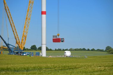 Rüzgar türbininin inşaat alanı, vinci kaldırıp kuleye yerleştirmek, yenilenebilir enerji ve güç konsepti, mavi gökyüzü, kopyalama alanı