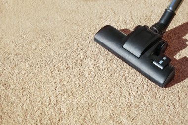 Halıdaki elektrik süpürgesi, apartman temizliğinde günlük ev işi, özellikle ev tozu akarlarına, fotokopi alanına, seçilmiş odak noktasına, dar alan derinliğine karşı.