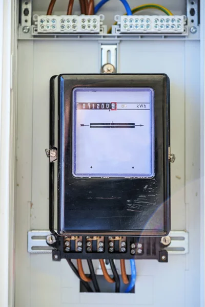 Analog electricity meter box behind glass, measures the consumption of a household, energy and power concept, copy space, selected focus, narrow depth of field