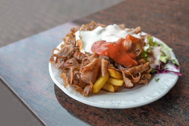 Almanya 'da bir Türk fast food restoranında servis edilen et, patates kızartması, salata ve iki soslu kebap tabağı, fotokopi alanı, seçilmiş odak, çok dar bir alan.