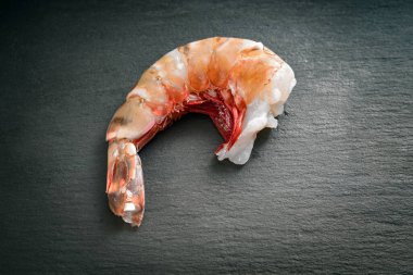 Kafası olmayan taze çiğ dev kral karidesi, karanlık bir levhada pişirmeye hazır ve temizdir, yukarıdan üst görünüm, boşluğu kopyala, seçilmiş odak