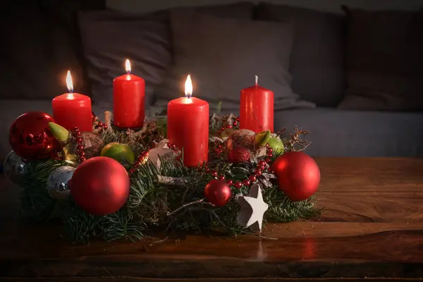 Στεφάνι Τρία Αναμμένα Κόκκινα Κεριά Και Χριστουγεννιάτικη Διακόσμηση Ξύλινο Τραπέζι — Φωτογραφία Αρχείου