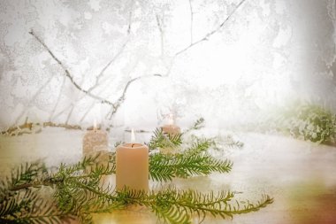 Sıcak beyaz mumlar ve köknar ağacı dalı, donmuş cam ve kış manzarası, mevsimlik dekorasyon ve Noel zamanı için tebrik kartı, kopyalama alanı, seçilmiş odak, dar alan derinliği