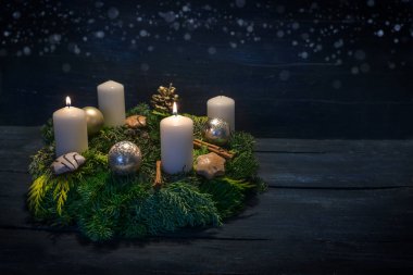 Green advent wreath with white candles, two are lit for second advent, Christmas decoration and cookies, dark blue wooden background with star bokeh, copy space, selected focus clipart