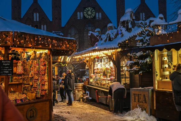 Lubeck, Almanya, 6 Aralık 2023: Tarihi eski Lubeck kasabasındaki Noel pazarında çatılarda karla kaplı tezgahlar satmak, kopya alanı, seçilmiş odak noktası,