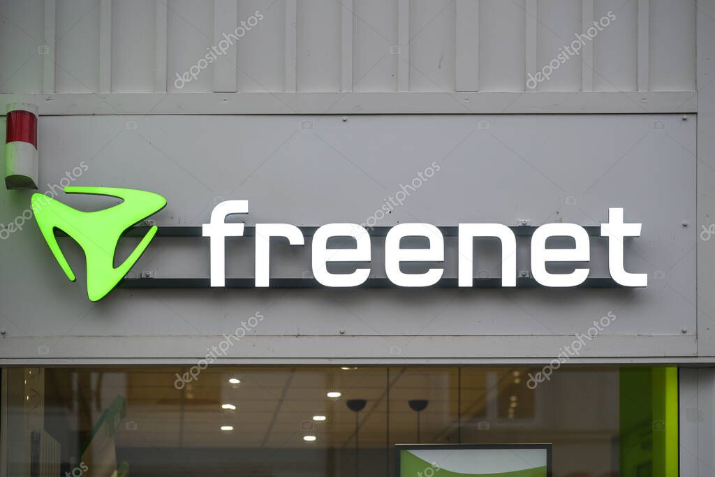 Rostock, Germany, January 26, 2024: Brand logo sign of the freenet AG on the gray store front facade in the city center, German company for mobile telecommunication and web content provider, copy space