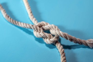 Mavi arkaplanda iki ipin düğümü, takım çalışması, iş ve birliktelik kavramı, kopyalama alanı, seçili odak, dar alan derinliği