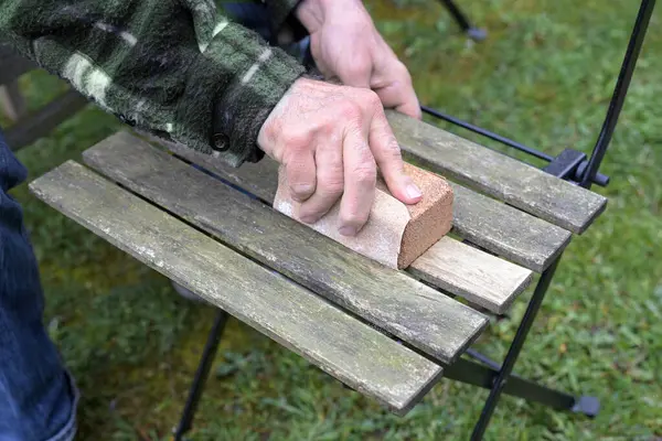 Człowiek Odnawiając Drewniane Krzesło Ogrodowe Szlifowanie Czyszczenie Drewna Wietrznego Usuwanie Obraz Stockowy