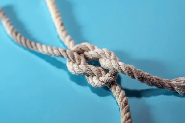 Knoten Aus Zwei Seilen Auf Blauem Hintergrund Konzept Für Teamwork lizenzfreie Stockbilder