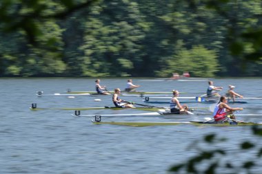Ratzeburg, Almanya, 1 Haziran 2024: Spor teknelerinde kürek çeken kadın rakipler Ratzeburg Gölü 'ndeki yelkenli yarışını kazanmak için mücadele ediyorlar.