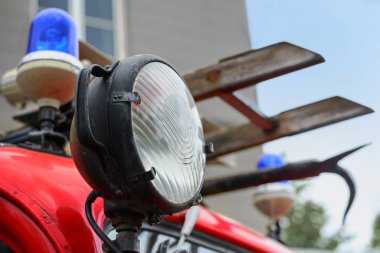 Kırmızı renkli itfaiye arabasının ayrıntıları, farları, mavi ışığı, merdiveni ve kancası, itfaiyecilik ve felaket kontrolü geçmişi, seçilmiş odak noktası