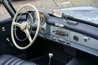 Ratzeburg, Almanya, 2 Haziran 2024: Klasik spor Mercedes-Benz 190 SL 'nin kokpit içi beyaz direksiyon ve radyo ile seçilmiş odak noktası