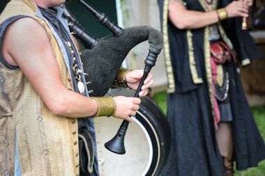 Deri ve ahşaptan yapılmış gayda çalan müzisyen tarihsel modellere dayanan, bir ortaçağ festivalinde folk müzik grubu, kopyalama alanı, seçilmiş odak, dar alan derinliği