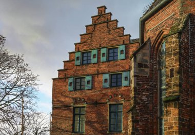Bremen, Almanya 'daki Martini Kilisesi' ndeki tarihi bina kırmızı tuğlalı mimari basamaklı ahşap panjurlu, bulutlu gökyüzü seçilmiş odaklı.