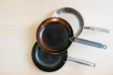 Karbon çeliği, paslanmaz çelikten yapılmış sağlıklı yemek pişirmek için doğal malzemeden üç tava ve sağlıksız yapışmaz kaplama olmadan dökme demir, kopyalama alanı, yukarıdan üst görünüm, seçilmiş odaklanma