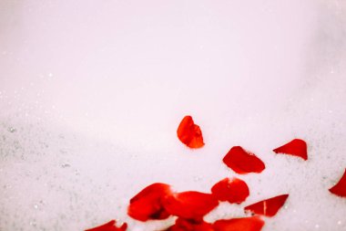 Bath water with rose petals. St. Valentine's Day bath. Aromatherapy with flower petals.