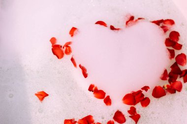 Bath water with rose petals. St. Valentine's Day bath. Aromatherapy with flower petals.