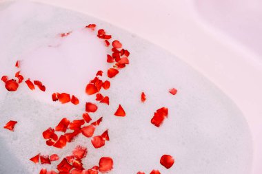 Bath water with rose petals. St. Valentine's Day bath. Aromatherapy with flower petals.