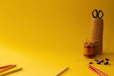 still life with pencils on a yellow background