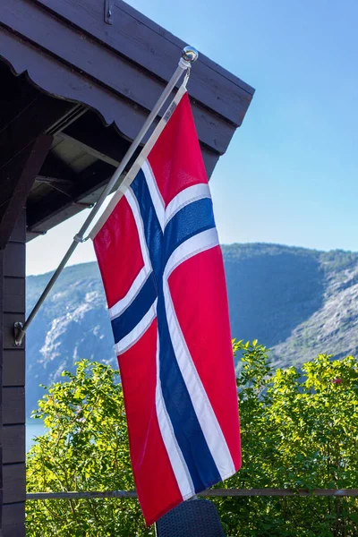 Norwegian Flags Hanging On Poles Outside A Building