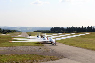 Gersfeld, Germany - July 23, 2021: Gliders (sailplanes) ready for takeoff on Wasserkuppe airfield in Rhoen Mountains. Great advances in sailplane development took place on the Wasserkuppe mountain.