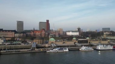 Hamburg, Germany - February 15, 2023: Aerial view over the Elbe towards the St. Pauli Piers with boats and Hamburg skyline. The St. Pauli Piers is one of Hamburgs major tourist attractions.
