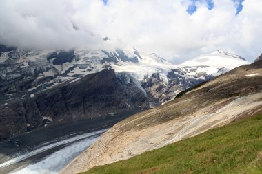 Avusturya 'nın yüksek Tauern Alplerinde buzullu dağ kar manzarası ve bulutlar