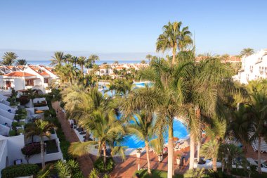 Yüzme havuzu, palmiye ağaçları ve Playa de las Americas 'taki Atlantik Okyanusu manzaralı otel panoraması, Tenerife