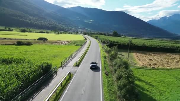 意大利施莱丝 2023年7月30日 蓝色保时捷911敞篷车驶过乡村 驶向一座村庄和高山阿尔卑斯山全景 这辆车是保时捷生产的跑车 — 图库视频影像