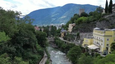 Merano 'da dağ manzaralı, Pudra Kulesi, villa köşkleri ve köprüsü olan nehir boyunca gezinti, Güney Tyrol, İtalya