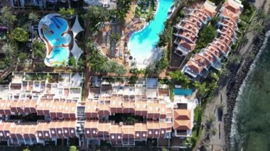 Tatil beldesi Playa de las Americas 'ta Atlantik Okyanusu boyunca uzanan havuz ve palmiye ağaçlarıyla dolu otel tatil beldeleri üzerinden Kanarya Adası Tenerife, İspanya