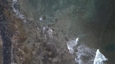 Atlantik Okyanusu 'nun yukarıdan görünen kıyısı boyunca uçmak ve İspanya' nın Tenerife Kanarya Adası 'ndaki Playa de las Americas tatil beldesinde dalgaların yükselmesi.