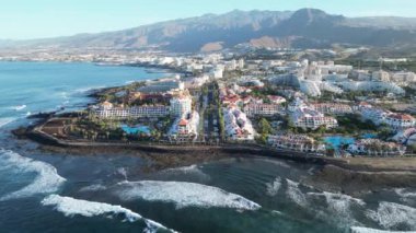 Atlantik Okyanusu üzerinden Playa de las Americas ve volkan tepelerine giden Panorama uçuşu Kanarya Adası Tenerife, İspanya 'da gündoğumunda gerçekleşmiştir.