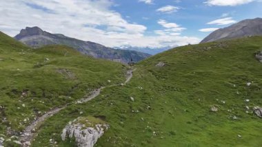 Yüksek dağ geçidi Pas de Cheville 'deki erkek yürüyüşçü (adam) üzerinden İsviçre Alpleri' nde Mont Gond ve Pennine Alpleri zirvesine doğru uçuyor.