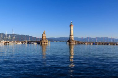 Liman girişi deniz feneri ve Bavyera Aslanı heykeli ile Constance Gölü 'ndeki Lindau adasında (Bodensee) dağ alpleri panorama, Almanya