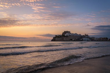 Eski Peniscola şehrinin güzel manzarası, tepesinde şato, ön planda deniz dalgaları, gün doğumunda Peniscola, Castellon, İspanya
