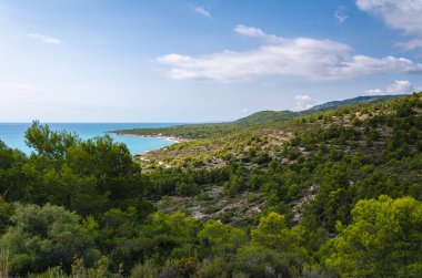Deniz kenarındaki Sierra de Irta Parkı 'nın doğal manzarası. Mavi gökyüzü ve bulutlarla dolu bir yaz günü. Peniscola, Castellon, İspanya.