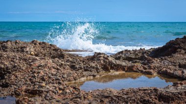 Sierra de Irta Doğal Parkı, Castellon, İspanya 'daki kayalık kıyı şeridine karşı deniz dalgaları kırılıyor.