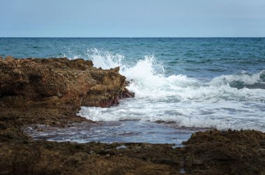Sierra de Irta Doğal Parkı, Castellon, İspanya 'daki kayalık kıyı şeridine karşı deniz dalgaları kırılıyor.